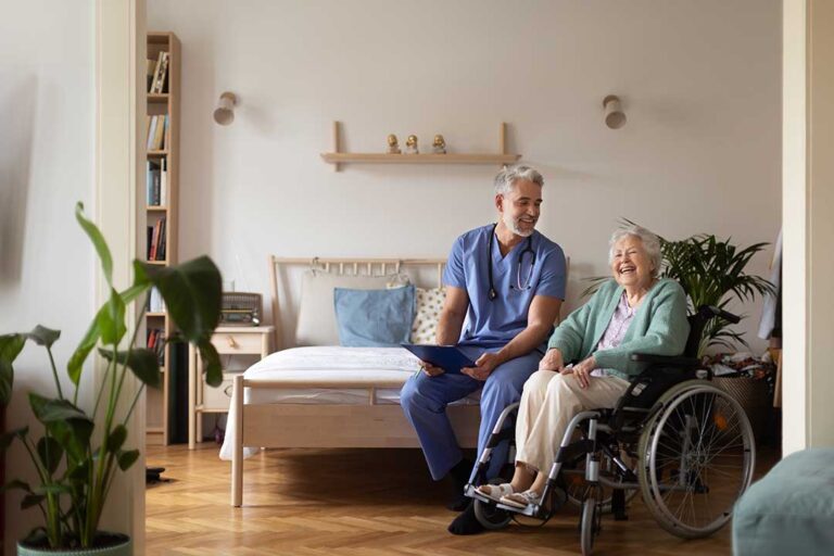 Older resident and caregiver reviewing a care plan beside religious and cultural personal items.
